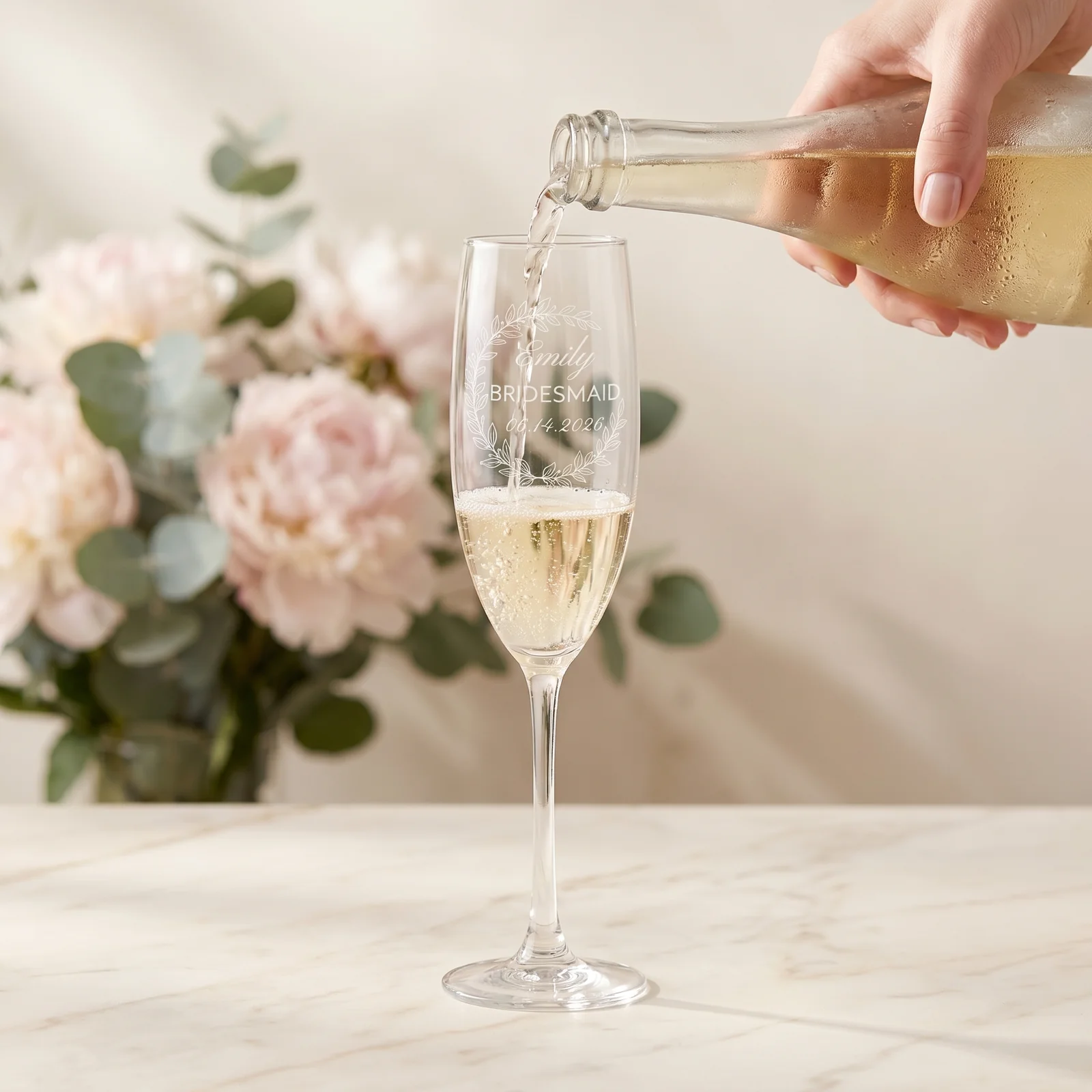 A soft scene of champagne being poured into a personalized flute.
