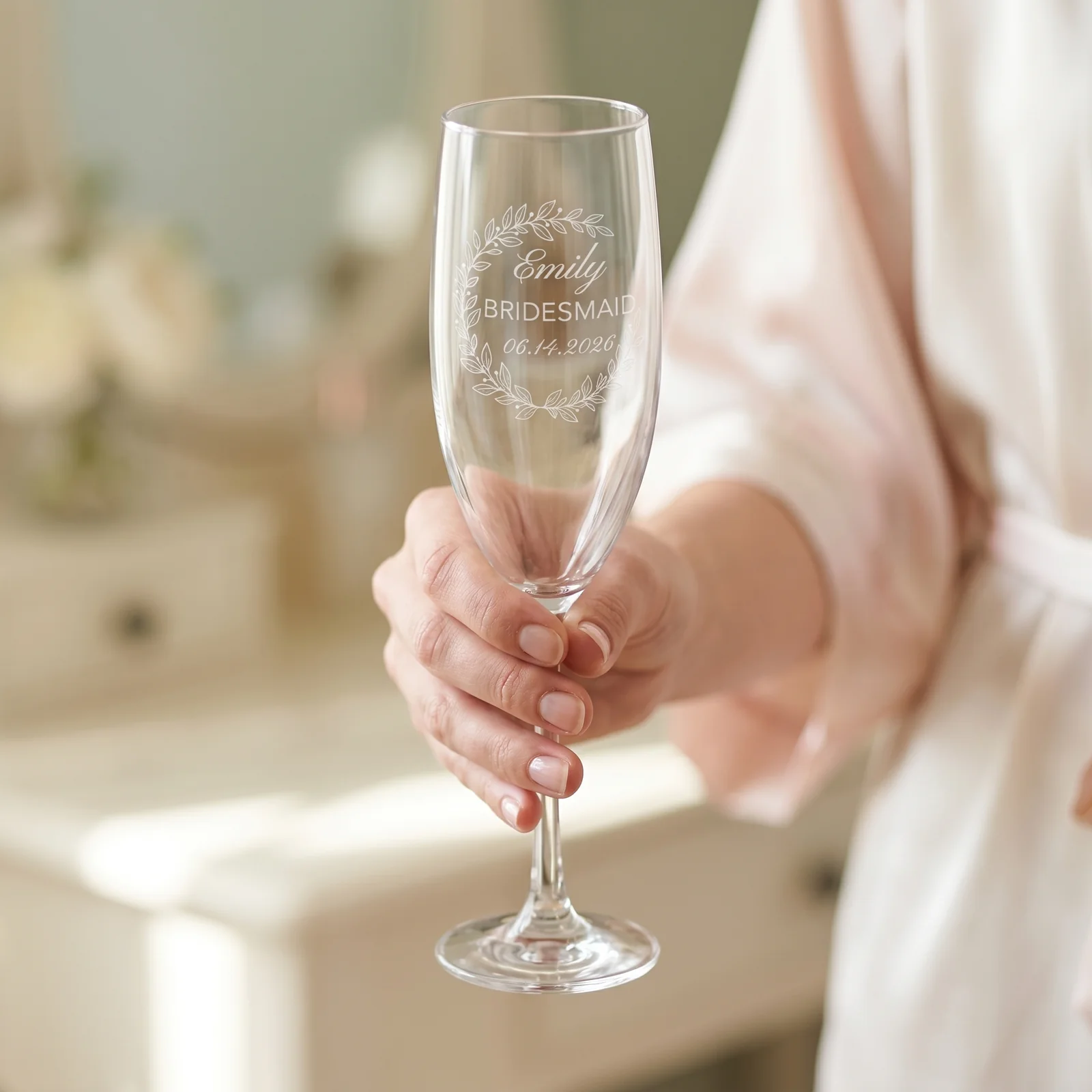 A bride's hand holding a personalized champagne flute.