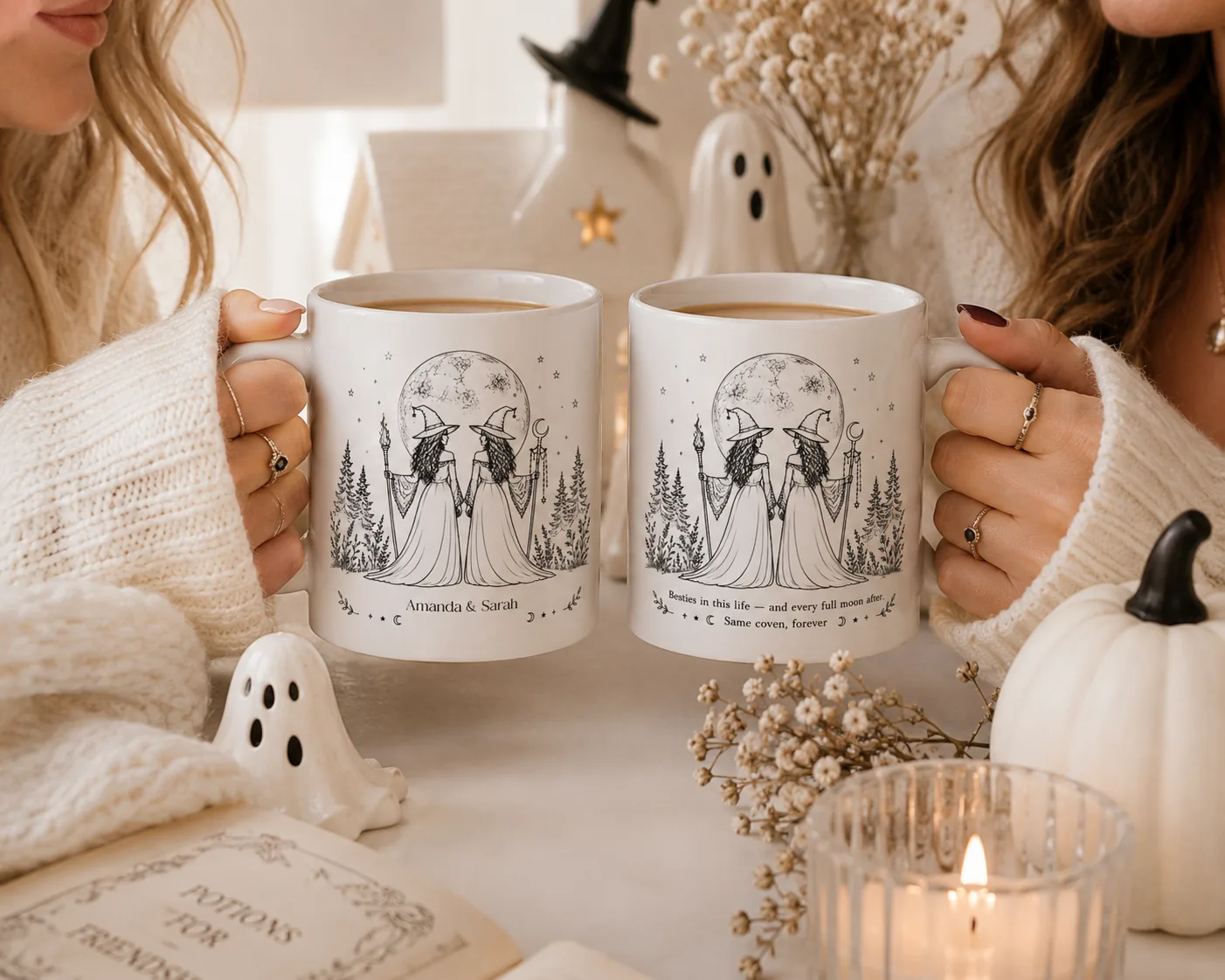 Two friends toasting with their matching personalized besties witch mugs, one printed with their names and one with the coven quote, beside an open book titled Potions for Friendship and soft Halloween styling with ghosts and dried flowers.